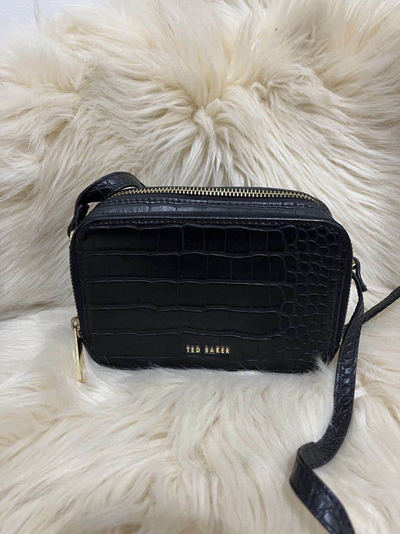 Ted Baker Black Croc Embossed Crossbody Bag (Category: Cross-body Bags) located in Naga. Submitted by ownlineshopp (Listing ID 1469502475, Image 2). Description: - Brand: Ted Baker - Color: Black with chic croc-embossed texture - Hardware: Premium gold-tone details and front logo lettering - Compartments: Secure double zippered compartments - Strap: Long, adjustable crossbody strap - Shape: Structured rectangular silhouette - Condition: Clean ins