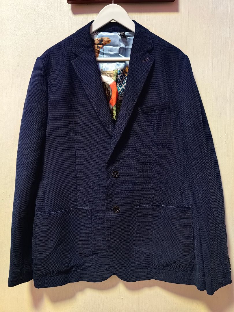 Ted Baker London Navy Blue Blazer Size 5 (Category: Coats, Jackets and Outerwear) located in Tarlac. Submitted by jeremiah.curator.2026 (Listing ID 1469403520, Image 1). Description: - Brand: Ted Baker - Color: Navy Blue - Size: 5 - Style: Two-button front closure with front patch pockets - Lining: Unique colorful desert scene graphic with a camel illustration and black/white geometric pattern - Details: Contrast red piping trim and branded Ted B