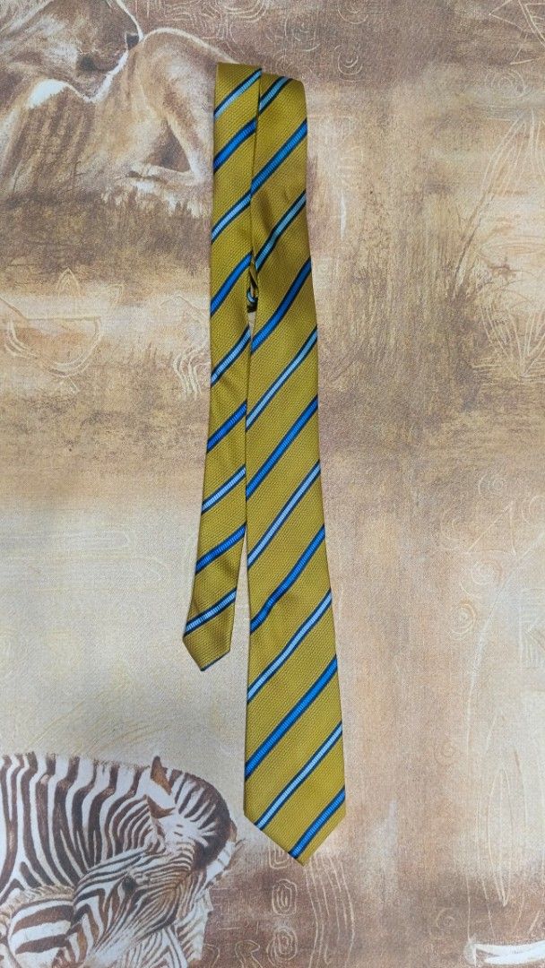 Ted Lapidus Paris Striped Necktie Yellow Blue (Category: Ties) located in Cavite. Submitted by navias (Listing ID 1469395936, Image 3). Description: Origin:UAE100% - Brand: Ted Lapidus Paris - Color/Pattern: Mustard yellow with diagonal blue and light blue stripes - Material: Textured woven fabric with branded back keeper loop - Width: Standard blade - Occasion: Ideal for formal wear, office outfits, and business meetings Transaction Details: -vi