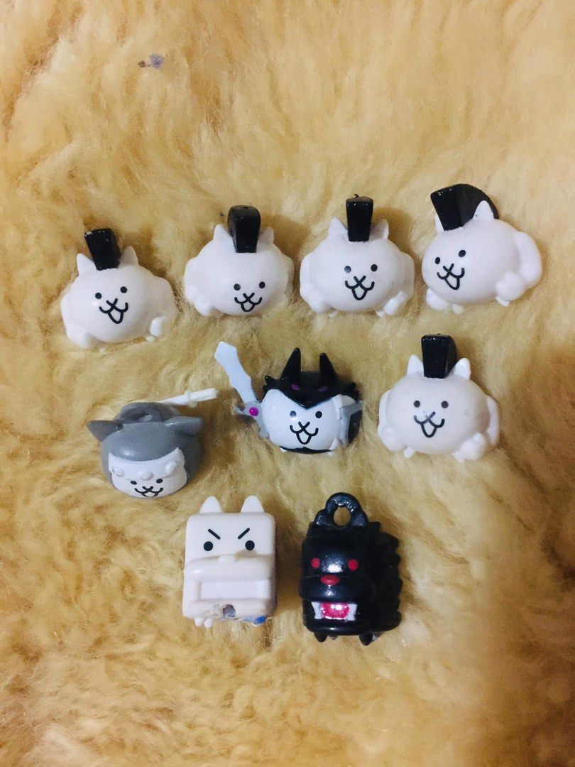 The Battle Cats Mini Figures Charms Lot (Category: Character Goods) located in Baguio. Submitted by izza_thrifty (Listing ID 1469567656, Image 1). Description: - Official-style The Battle Cats mini figures and charms bundle - Includes standard mohawk cats, grey cat, dark armored character with sword, square cat, and red-eyed black dog - Features loop attachments on top of several pieces for hanging or display - Condition: Minor paint wear spots d