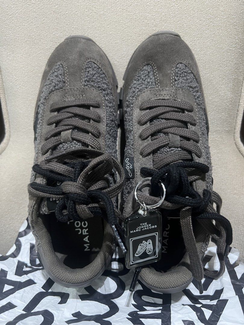 The Jogger Marc Jacobs Teddy Sneakers Size 39 (Category: Sneakers) located in Manila. Submitted by trustedceller (Listing ID 1469476527, Image 3). Description: - Brand: Marc Jacobs (The Jogger) - Color: Dark grey - Size: EU 39/ Size US 8 Runs small, best fit to US 7.5 - Condition: Brand new / Zero wear on soles - Materials: Textured fleece upper with suede and smooth leather overlays - Features: Chunky rubber tread sole with lettering underneath,