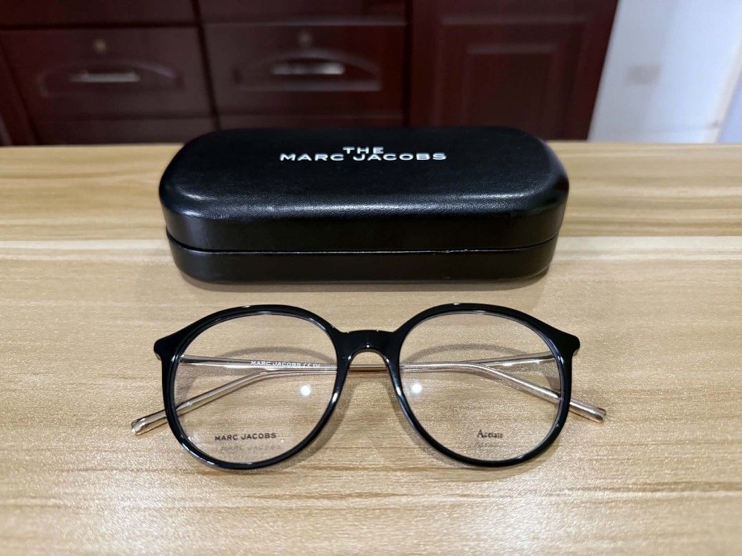 The Marc Jacobs Black Round Acetate Eyeglasses with Case (Category: Sunglasses & Eyewear) located in Bacoor. Submitted by sepiyow (Listing ID 1469567960, Image 2). Description: - Brand: The Marc Jacobs - Style: Round frame glasses in a chic black and gold tone - Material: Premium acetate front with slim gold-finish temples - Lenses: Fitted with demo lenses (ready for your own prescription or non-prescription wear) - Inclusion: Original black hard