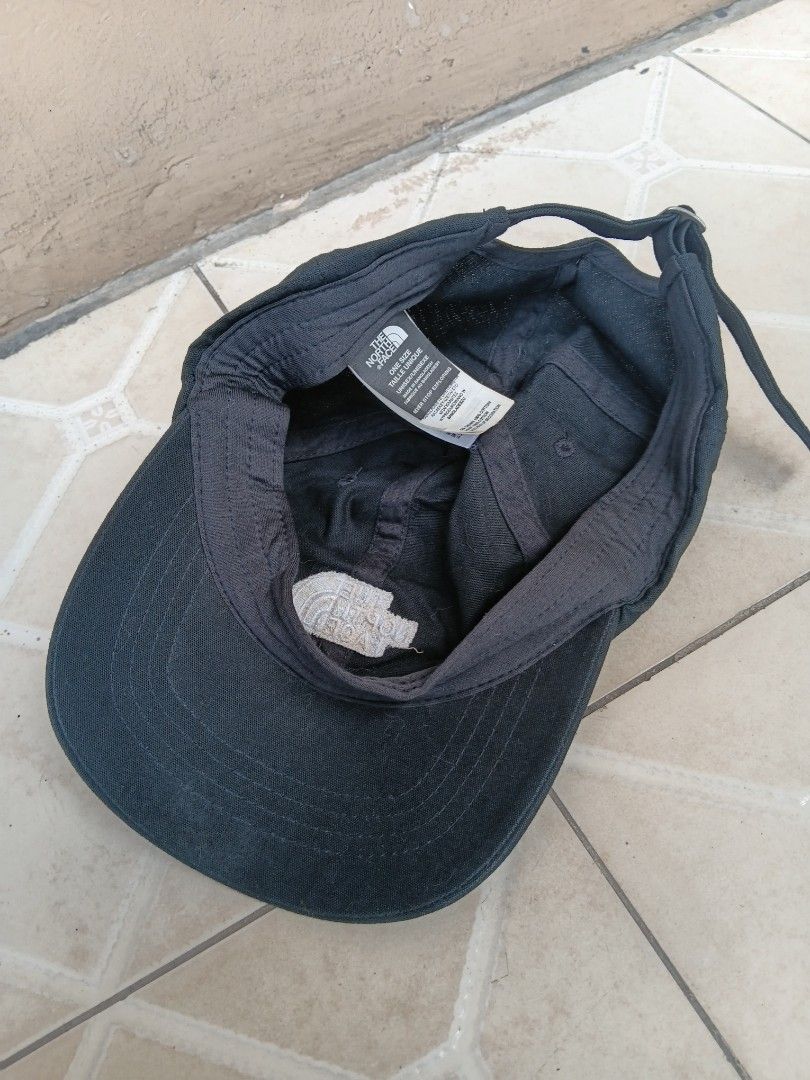 The North Face Black Baseball Cap (Category: Caps & Hats) located in Manila. Submitted by grandflower-547aee (Listing ID 1469496677, Image 2). Description: - Brand: The North Face - Color: Classic Black - Material: 100% Cotton (Crown and Visor) - Condition: Clean interior with authentic holographic tag intact - Design: Unisex, one size with adjustable strap closure for a custom fit - Details: Features embroidered logo on the front panel and inter