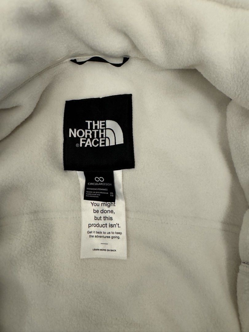 The North Face Circular Design Fleece Jacket (Category: Coats, Jackets and Outerwear) located in Taguig. Submitted by sqaumejada (Listing ID 1469474374, Image 2). Description: - Brand: The North Face - Style: Full-zip fleece jacket with high collar - Color: Cream with contrasting black panels and white embroidered logo - Size: Women's XL (UNISEX) - Features: Secure zip pockets on both sides, soft fleece material - Details: Circular Design tag, ma