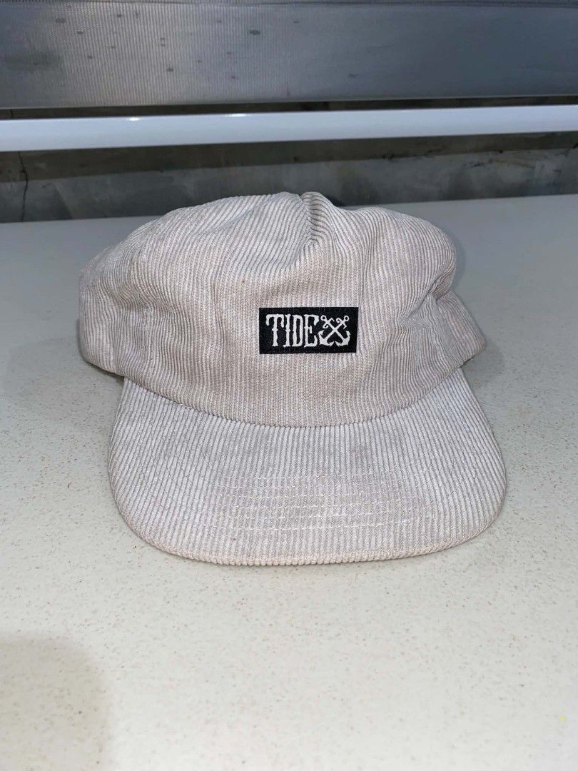 Tide Apparel Corduroy Snapback Cap Beige (Category: Caps & Hats) located in Baler. Submitted by mariokush193815 (Listing ID 1469452102, Image 1). Description: - Brand: Tide Apparel - Material: 100% durable acrylic corduroy - Color: Classic beige with black and white embroidered logo patch - Design: Structured crown with a flat brim - Fit: Adjustable black plastic snapback closure for a custom fit - Details: Includes signature small brand tag on t