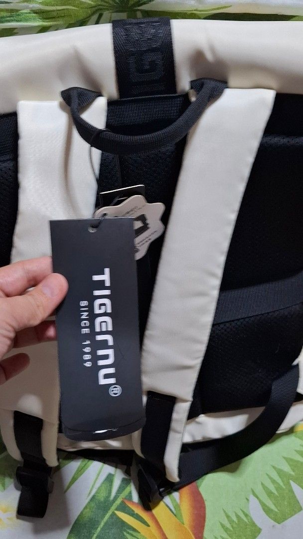 Tigernu Off-White Laptop Backpack (Category: Backpacks) located in Maragondon. Submitted by thatgirlpibi (Listing ID 1469535284, Image 3). Description: Tigernu brand backpack in off-white color with black straps and buckle closure. Includes original tag attached. Multiple compartments with zipper closures on the front flap and body. Padded black mesh back panel and comfortable shoulder straps. Designed to fit a 14-inch laptop. Made of Oxford mate