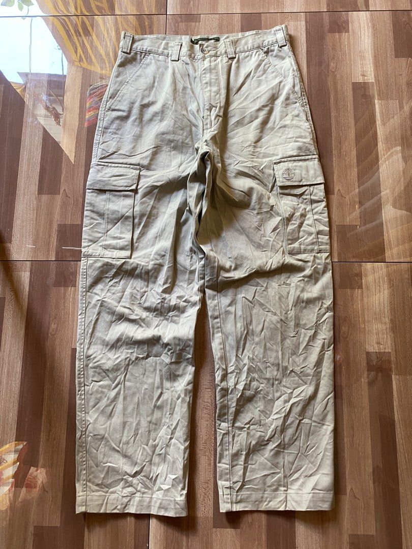 Timberland Khaki Cargo Pants Size 32 (Category: Jeans) located in Pandi. Submitted by nasya_thrift_collection2023 (Listing ID 1469415222, Image 1). Description: - Brand: Timberland - Style: Khaki cargo pants - Size: 32 - Material: Heavy cotton twill fabric - Features: Multiple utility pockets, embroidered tree logo on pocket flap, YKK zipper fly with button closure - Condition: Solid overall with minor fraying and missing sections on the main bra