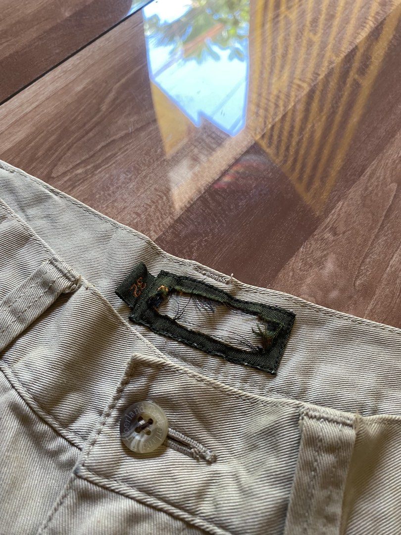 Timberland Khaki Cargo Pants Size 32 (Category: Jeans) located in Pandi. Submitted by nasya_thrift_collection2023 (Listing ID 1469415222, Image 3). Description: - Brand: Timberland - Style: Khaki cargo pants - Size: 32 - Material: Heavy cotton twill fabric - Features: Multiple utility pockets, embroidered tree logo on pocket flap, YKK zipper fly with button closure - Condition: Solid overall with minor fraying and missing sections on the main bra