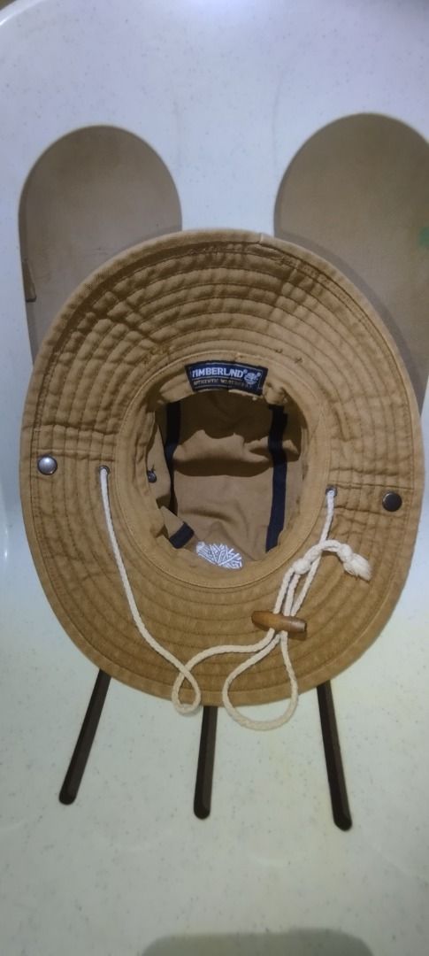 Timberland Tan Bucket Hat Sun Hat (Category: Caps & Hats) located in Caloocan City. Submitted by jrdar (Listing ID 1469496515, Image 3). Description: - Brand: Timberland - Color: Classic Tan - Material: Durable canvas - Logos: Embroidered tree logo on front, text logo on back - Features: Adjustable white chin cord with toggle and leather accents - Versatility: Snap buttons on the sides to wear the brim up - Condition: Excellent, well-maintained.
