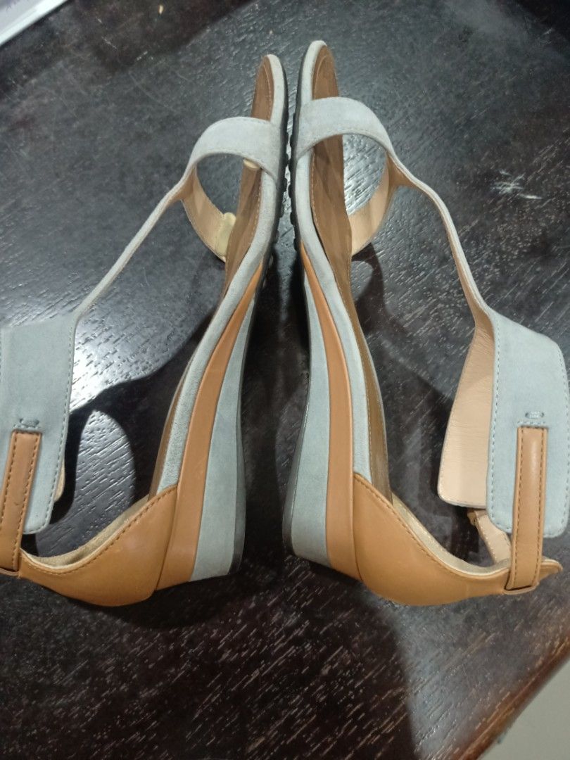 Tod's T-strap Wedge Sandals Light Blue Tan Size (Category: Wedges) located in Manila. Submitted by argalaeq (Listing ID 1469449248, Image 2). Description: - Authentic Tod's wedge sandals - Light blue suede front strap with tan leather footbed and back strap - Adjustable ankle buckle for a secure fit - Wedge heel wrapped in matching blue and tan materials - Gold TOD'S logo stamped inside the heel.