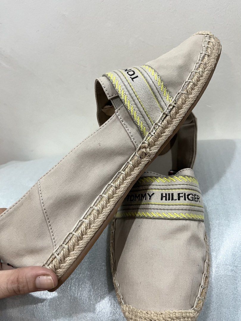 Tommy Hilfiger Beige Canvas Espadrilles Size US 9.5 (Category: Flats & Sandals) located in Talisay. Submitted by cherylu (Listing ID 1469570461, Image 2). Description: - Brand: Tommy Hilfiger - Style: Canvas slip-on espadrilles with woven jute detailing - Color: Beige with beige and yellow branded ribbon strap - Size: EUR 41 / UK 7 / US 9.5 / CM 26 - Features: Brown inner sole with embossed logo, textured rubber outsole with branding - Origin: Ma