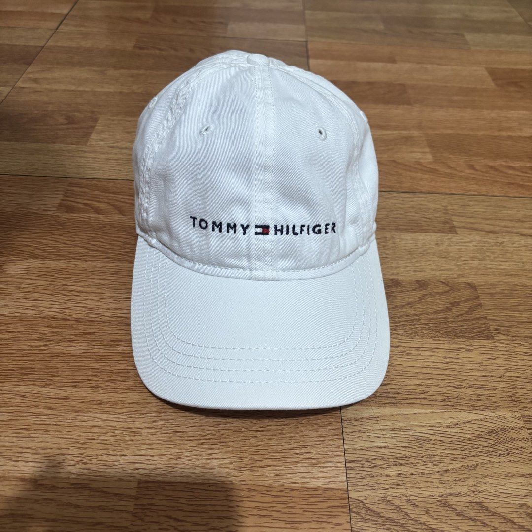 Tommy Hilfiger White Baseball Cap One Size (Category: Caps & Hats) located in Manila. Submitted by jemiruxd (Listing ID 1469509713, Image 1). Description: - Brand: Tommy Hilfiger - Material: 100% Cotton Twill - Color: White with classic embroidered front logo - Closure: Brown strapback with metal flag logo adjuster - Size: One Size Fits All (Made in Bangladesh) - Condition: Good, with minor discoloration near the inner brim from previous wear.