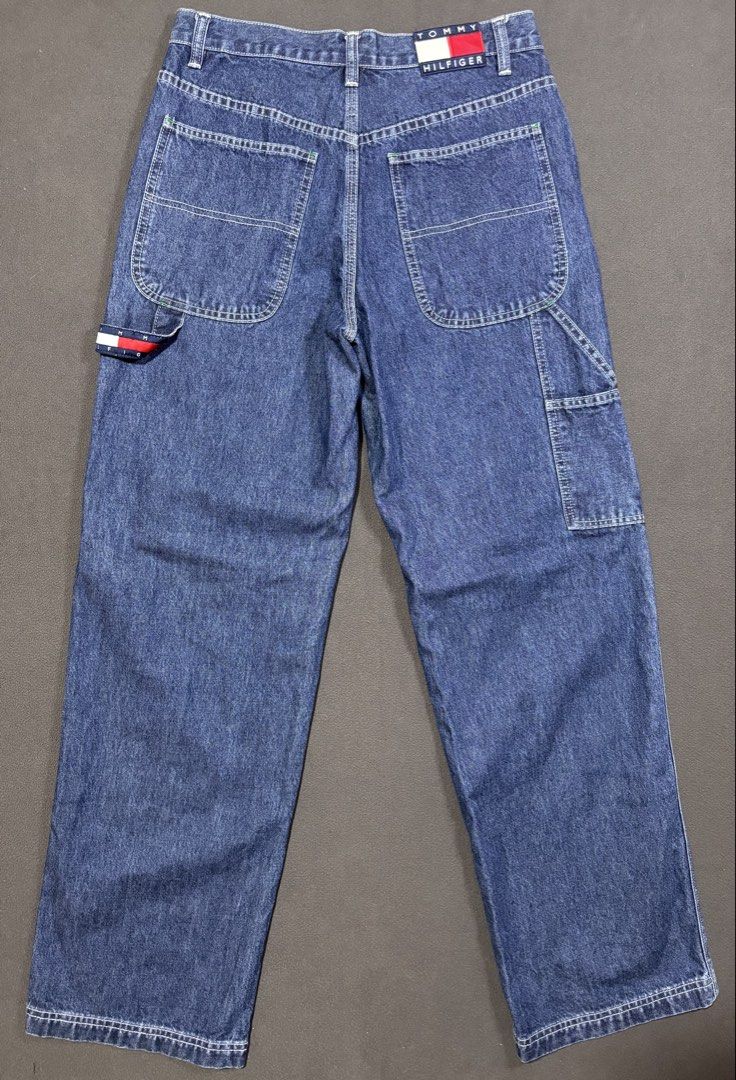 Tommy Jeans Carpenter Denim Pants Size 31 (Category: Jeans) located in Mabalacat. Submitted by _limitlessfashion (Listing ID 1469423105, Image 2). Description: - Brand: Tommy Jeans - Style: Denim carpenter pants with classic blue wash - Size 31 - Length 41 - Hem 9.5 - No issue, in good condition - Fit: Relaxed fit with button fly closure - Details: Utility pockets, side hammer loop, and contrast white stitching - Branding: Iconic Tommy Hilfiger f