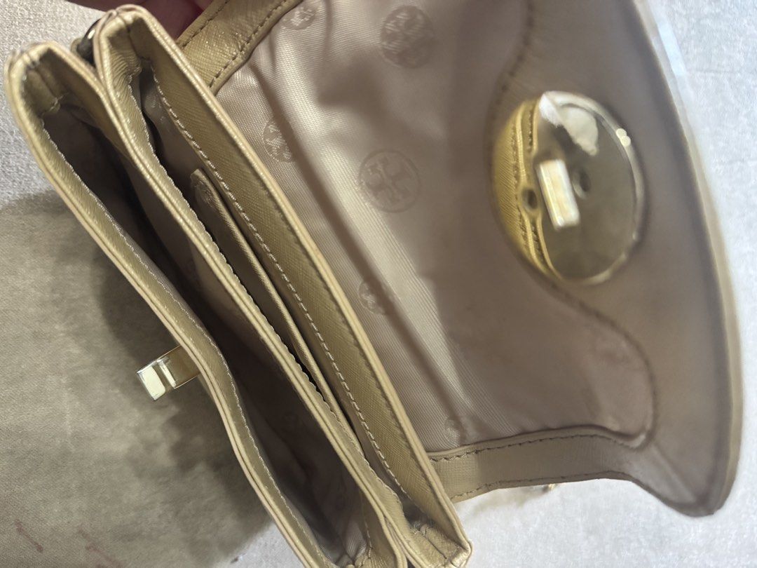 Tory Burch Beige Crossbody Bag with Strap (Category: Luxury Bags & Wallets) located in Pasig City. Submitted by _aboutagal (Listing ID 1469406854, Image 2). Description: - Authentic beige Tory Burch crossbody bag - Durable textured saffiano leather with gold-tone hardware - Iconic logo twist lock closure on front flap - Removable and adjustable strap for versatile styling - Multiple interior compartments with printed fabric lining - Compact and l