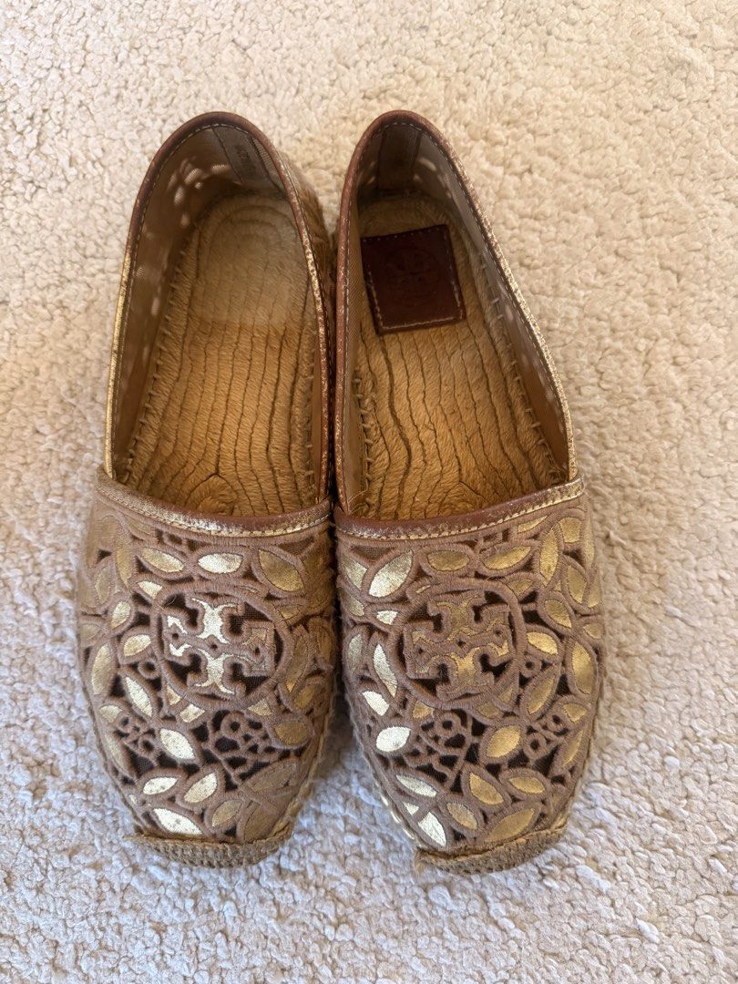 Tory Burch Gold Cutout Espadrilles Flats (Category: Flats & Sandals) located in Muntinlupa City. Submitted by pattti_gv (Listing ID 1469453666, Image 2). Description: - Brand: Tory Burch - Style: Slip-on espadrille flats - Color/Design: Gold with chic cutout pattern - Materials: Leather insoles with embossed logo, classic jute-wrapped soles - Condition: Regular signs of wear on soles and footbeds - Ideal for: Warm weather, casual chic outfits, an