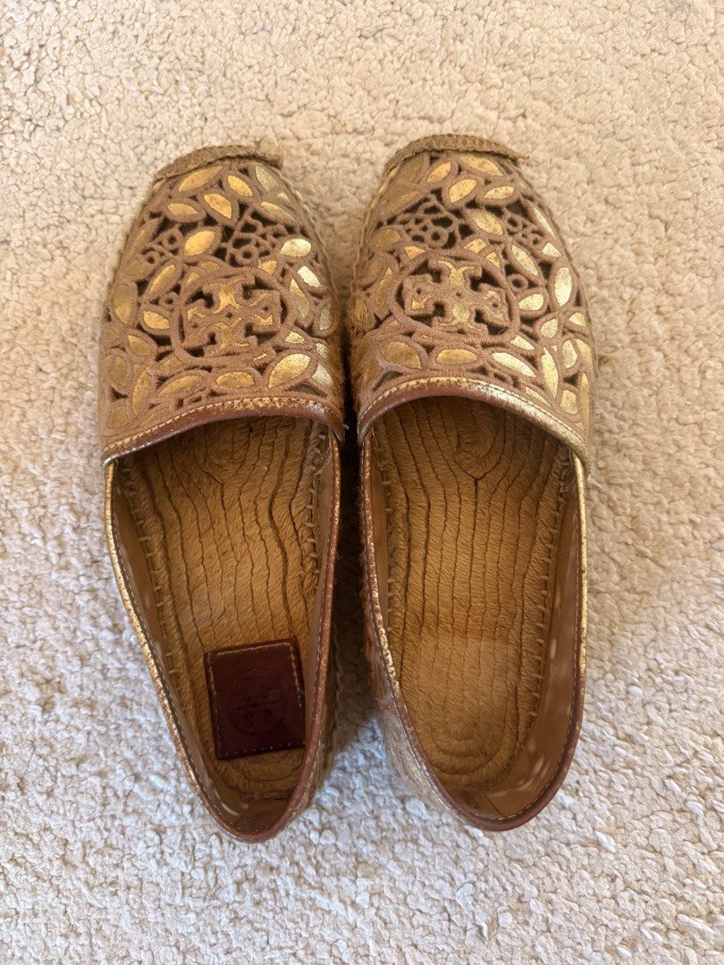 Tory Burch Gold Cutout Espadrilles Flats (Category: Flats & Sandals) located in Muntinlupa City. Submitted by pattti_gv (Listing ID 1469453666, Image 1). Description: - Brand: Tory Burch - Style: Slip-on espadrille flats - Color/Design: Gold with chic cutout pattern - Materials: Leather insoles with embossed logo, classic jute-wrapped soles - Condition: Regular signs of wear on soles and footbeds - Ideal for: Warm weather, casual chic outfits, an