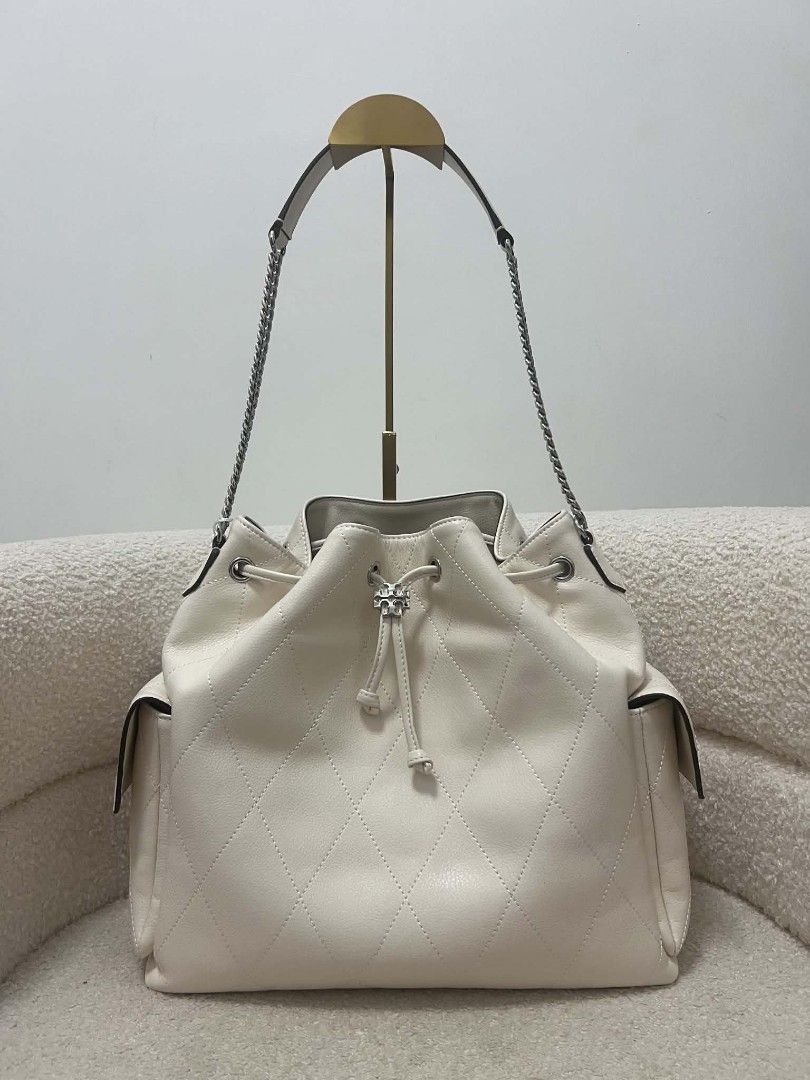 Tory Burch Quilted Charlie Large Drawstring Bag (Category: Shoulder Bags) located in Paoay. Submitted by rvf1230 (Listing ID 1469427145, Image 2). Description: - Brand: Tory Burch - Material: Luxurious off-white quilted leather - Closure: Secure drawstring top - Hardware: Sleek silver hardware with stylish chain strap detail - Storage: Handy side pockets on both sides - Structure: Clean flat base for easy placement .