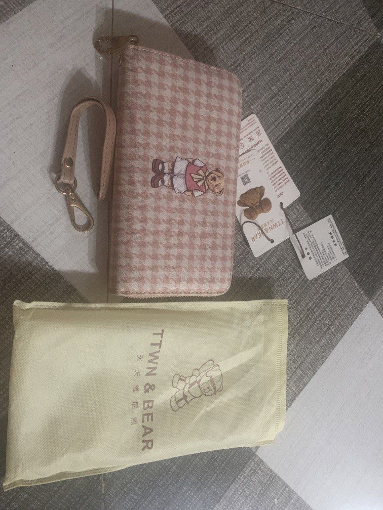 TTWN & BEAR Pink Houndstooth Long Zip Wallet (Category: Wallets & Card holders) located in Bocaue. Submitted by bajiborgy08 (Listing ID 1469522773, Image 1). Description: - Brand: TTWN & BEAR - Design: Pink houndstooth pattern with cute teddy bear graphic - Hardware: Gold-tone with bear-shaped zipper pulls - Interior: Multiple card slots, cash compartments, and zippered coin pocket - Inclusions: Matching wrist strap, original tags, and dust bag -