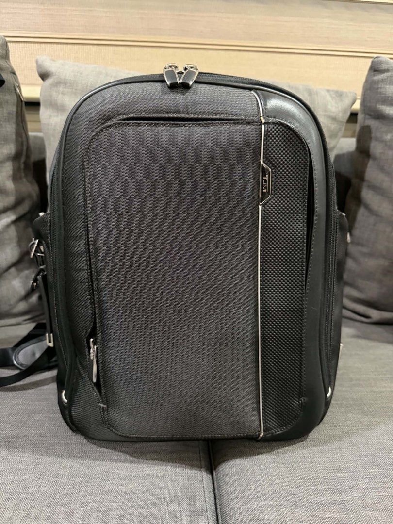 TUMI Black Business Laptop Backpack (Category: Backpacks) located in Manila. Submitted by mialuna_ (Listing ID 1469422120, Image 1). Description: - Authentic black TUMI backpack made from durable nylon with stylish leather trim - Multiple exterior and interior zippered compartments for easy daily organization - Built-in key leash and metal TUMI Tracer plate for security - Comfortable padded shoulder straps and sturdy top handle - Sleek dark blue 