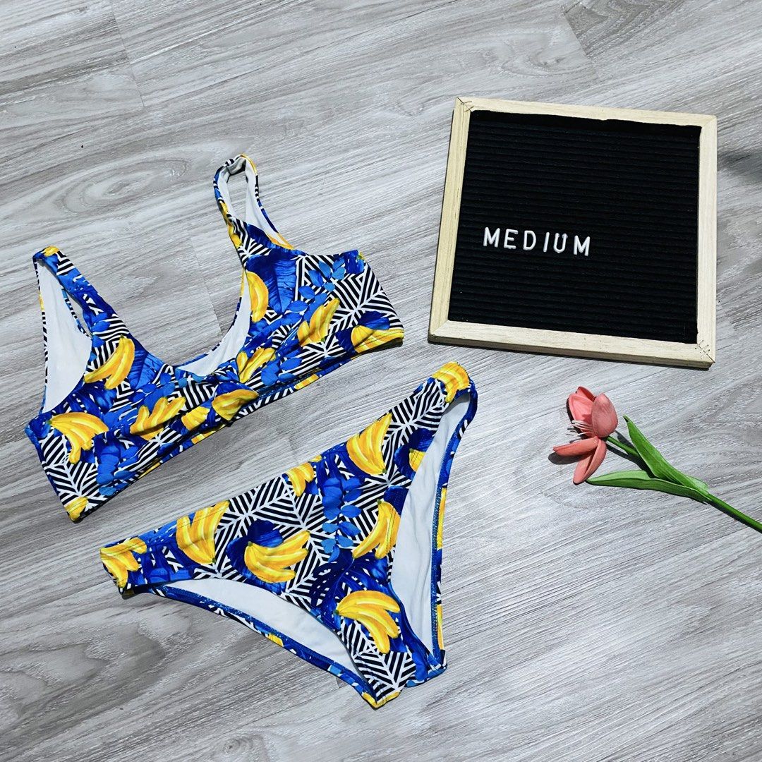 Two-piece banana print bikini set (Category: Bikinis & Swimsuits) located in Caloocan City. Submitted by lovemyclothes21 (Listing ID 1469497264, Image 1). Description: - Style: Two-piece swimsuit set - Size: Medium - Design: Blue base with bold yellow banana print and geometric stripes - Top: Scoop neck with stylish twisted front detail - Bottoms: Classic fit with white lining - Condition: Brand new, ready for the beach or pool.