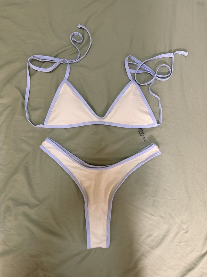 Two-piece bikini set light blue and cream (Category: Bikinis & Swimsuits) located in Makati City. Submitted by andzr. (Listing ID 1469543311, Image 1). Description: - Style: Triangle bikini top with matching high-cut, cheeky bottoms - Color: Cream with light blue trim and piping details - Size: Medium (tag attached) - Material: Polyimide and elastane blend (Made in China) - Care: Hand wash separately - Condition: Clean and neat overall.