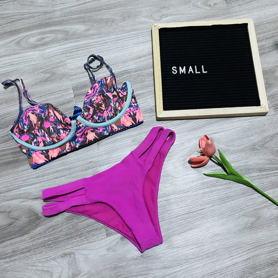 Two-piece bikini set printed top (Category: Bikinis & Swimsuits) located in Caloocan City. Submitted by lovemyclothes21 (Listing ID 1469496401, Image 1). Description: - Size: Small - Style: Two-piece swimsuit set - Top: Underwire support, colorful abstract print, and light blue trim - Bottoms: Solid purple ribbed fabric with multi-strap side details - Ideal for: Beach days and pool lounging.