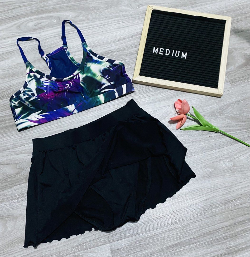 Two-piece Swimsuit Tropical (Category: Bikinis & Swimsuits) located in Caloocan City. Submitted by lovemyclothes21 (Listing ID 1469496981, Image 1). Description: - Size: Medium (Two-piece set) - Top: Blue and purple tropical leaf print with adjustable straps and racerback design - Bottoms: Solid black with a built-in brief and attached swim skirt overlay - Condition: Clean fabric throughout, great for the beach or pool.