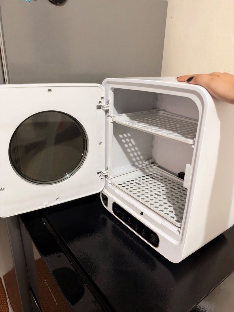 Ultraviolet Rays UV Sterilizer and Dryer Cabinet (Category: Breastfeeding & Bottle Feeding) located in Quezon City. Submitted by krengkreng (Listing ID 1469448935, Image 3). Description: - Type: Countertop UV sterilizer and dryer cabinet - Design: Clean white exterior/interior with a stylish round glass door - Controls: Digital touch panel at the bottom - Modes: Auto, Dry, UV, and Air - Includes: Removable inner shelves for flexible organization 