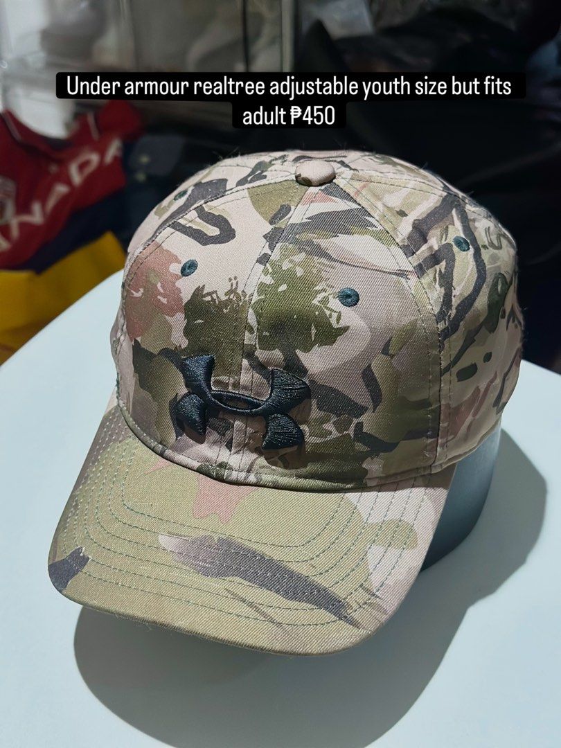 Under Armour Realtree Camo Adjustable Youth Hat (Category: Caps & Hats) located in Daet. Submitted by thrifthings2018 (Listing ID 1469482468, Image 1). Description: - Brand: Under Armour - Design: Realtree camo pattern with black embroidered front logo - Size: Youth OSFA (also fits adults), fully adjustable back strap - Material: 98% polyester, 2% elastane - Condition: Clean interior with branded taping - Origin: Made in China.