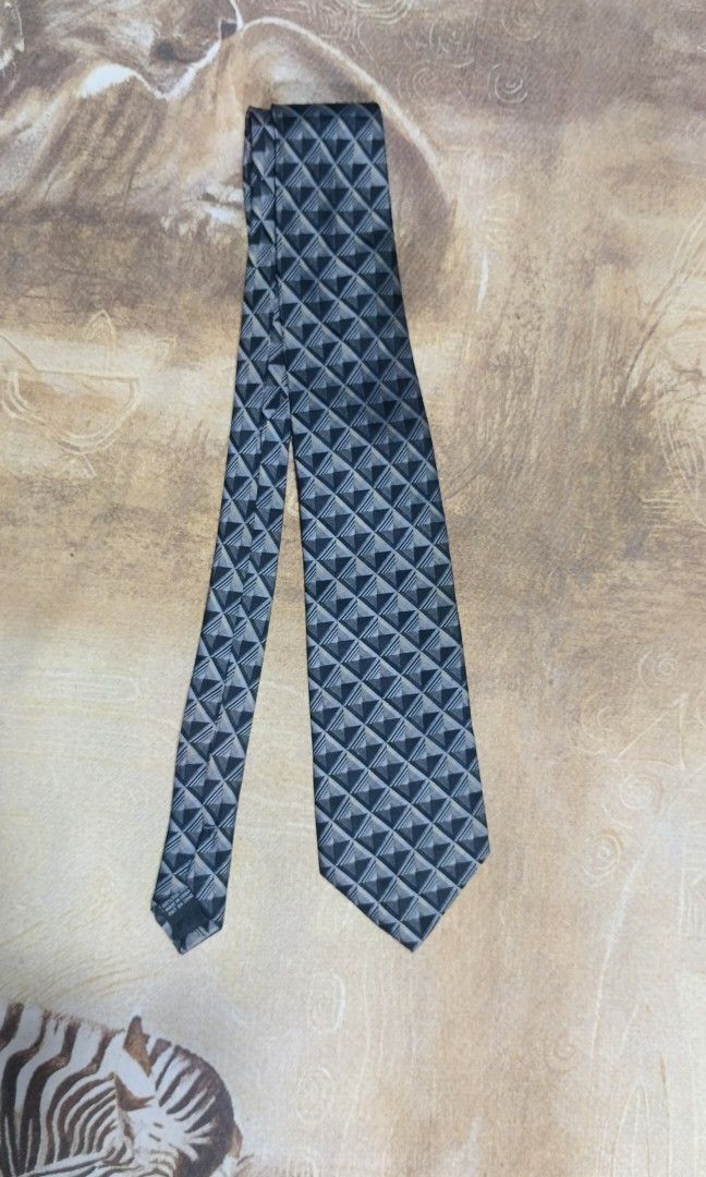 Van Heusen Silk Geometric Pattern Necktie (Category: Ties) located in Cavite. Submitted by navias (Listing ID 1469396350, Image 3). Description: Origin:UAE100% - Brand: Van Heusen - Material: 100% pure silk for a premium feel - Design: Modern geometric triangle pattern in sleek shades of grey and black - Width: Standard blade width suitable for any professional setting - Features: Includes a back keeper loop and original brand label stitched insi