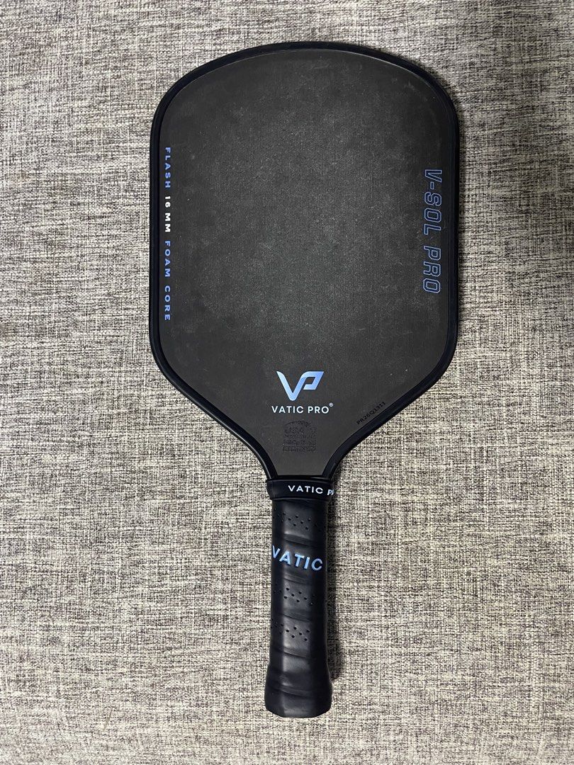 Vatic Pro V-Sol Pro Flash 16mm Pickleball Paddle (Category: Racket and Ball Sports) located in Cordon. Submitted by secondgreatt (Listing ID 1469406887, Image 2). Description: - Brand: Vatic Pro V-Sol Pro Flash - Thickness: 16mm foam core construction for power and control - Condition: Pristine, zero wear marks on the face or edge guard - Design: Sleek black surface with striking blue lettering and branding - Handle: Standard perforated grip wrap