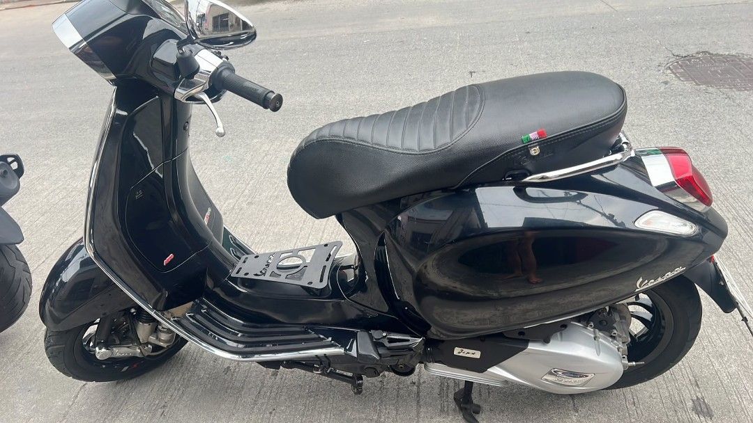 Vespa Sprint 150 Black Scooter (Category: Motorbikes for Sale) located in Las Pinas. Submitted by raebelran (Listing ID 1469454305, Image 2). Description: Black Vespa Sprint 150 scooter in clean condition. Custom black wheels, custom exhaust, and a stitched leather seat. Center floor mat rack installed. Glossy finish all around, no major scratches visible. Smooth ride, great daily commuter..