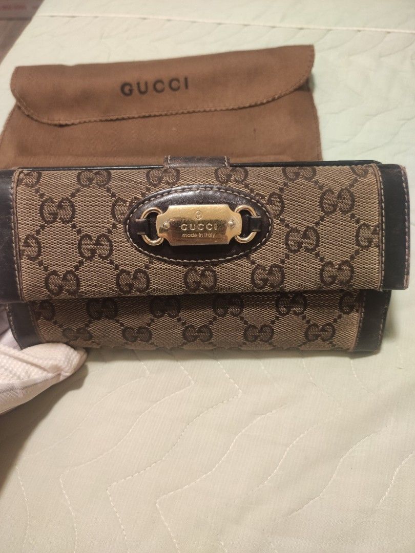 Vintage Authentic Gucci Long Wallet Brown (Category: Luxury Bags & Wallets) located in Paranaque City. Submitted by daddyu (Listing ID 1469425912, Image 1). Description: - Authentic Gucci long wallet in classic brown monogram canvas - Dark brown leather trim and interior lining with gold-tone hardware - Snap flap closure with a stylish front metal plate - Organized interior with multiple card slots, cash compartments, and a zipped coin pocket - C