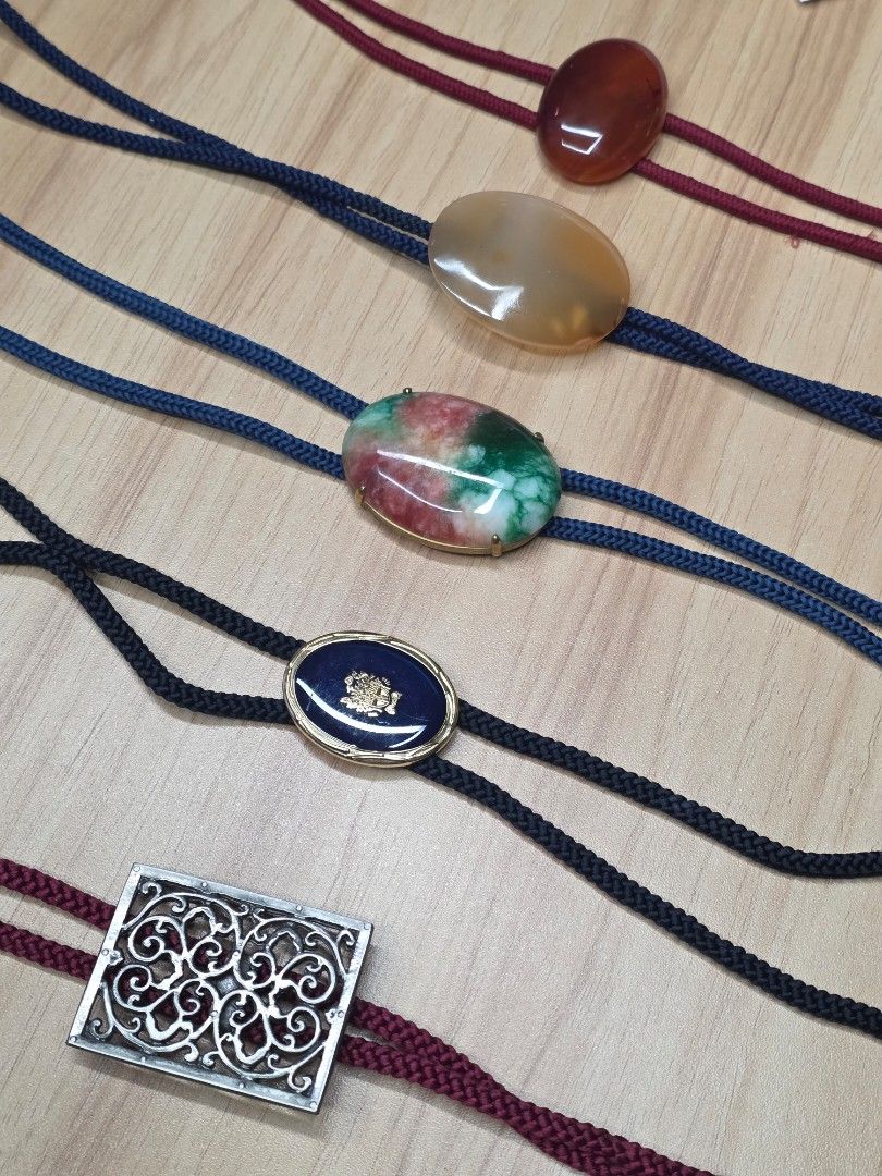 Vintage Bolo Tie Set Assorted Gemstone Western Necktie (Category: Ties) located in Quezon City. Submitted by gonzzzzz (Listing ID 1469520290, Image 3). Description: - Set of 5 unique bolo ties for western wear or statement looks - Centerpieces include reddish-brown stone, translucent agate, green/red mottled stone, blue enamel with crest, and silver-tone metal filigree - Features burgundy and dark blue braided cords with metal tips - Selling as a