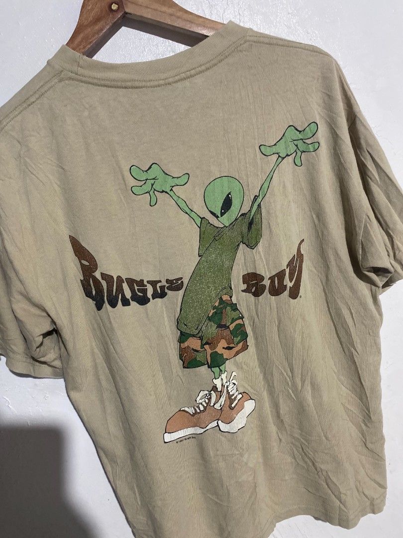 Vintage Bugle Boy Alien Graphic T-shirt Beige Medium (Category: Tshirts & Polo Shirts ) located in Maasin. Submitted by trippythirftyyy (Listing ID 1469481075, Image 3). Description: - Brand: Bugle Boy - Color: Tan - Size/Fit: Relaxed 90s streetwear fit - Design: Small alien logo on chest pocket, large 1997 copyrighted alien graphic on the back - Details: Short sleeves, crew neckline, vintage condition.