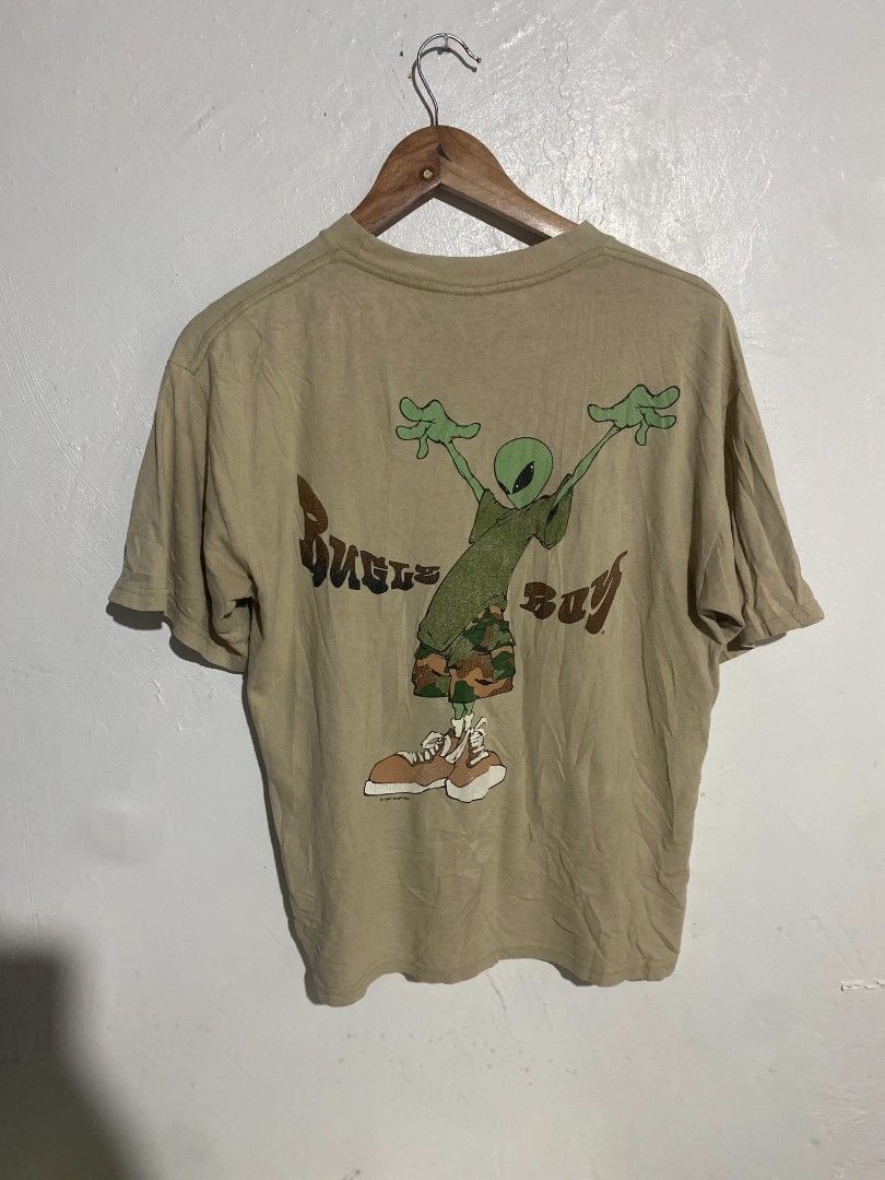 Vintage Bugle Boy Alien Graphic T-shirt Beige Medium (Category: Tshirts & Polo Shirts ) located in Maasin. Submitted by trippythirftyyy (Listing ID 1469481075, Image 2). Description: - Brand: Bugle Boy - Color: Tan - Size/Fit: Relaxed 90s streetwear fit - Design: Small alien logo on chest pocket, large 1997 copyrighted alien graphic on the back - Details: Short sleeves, crew neckline, vintage condition.