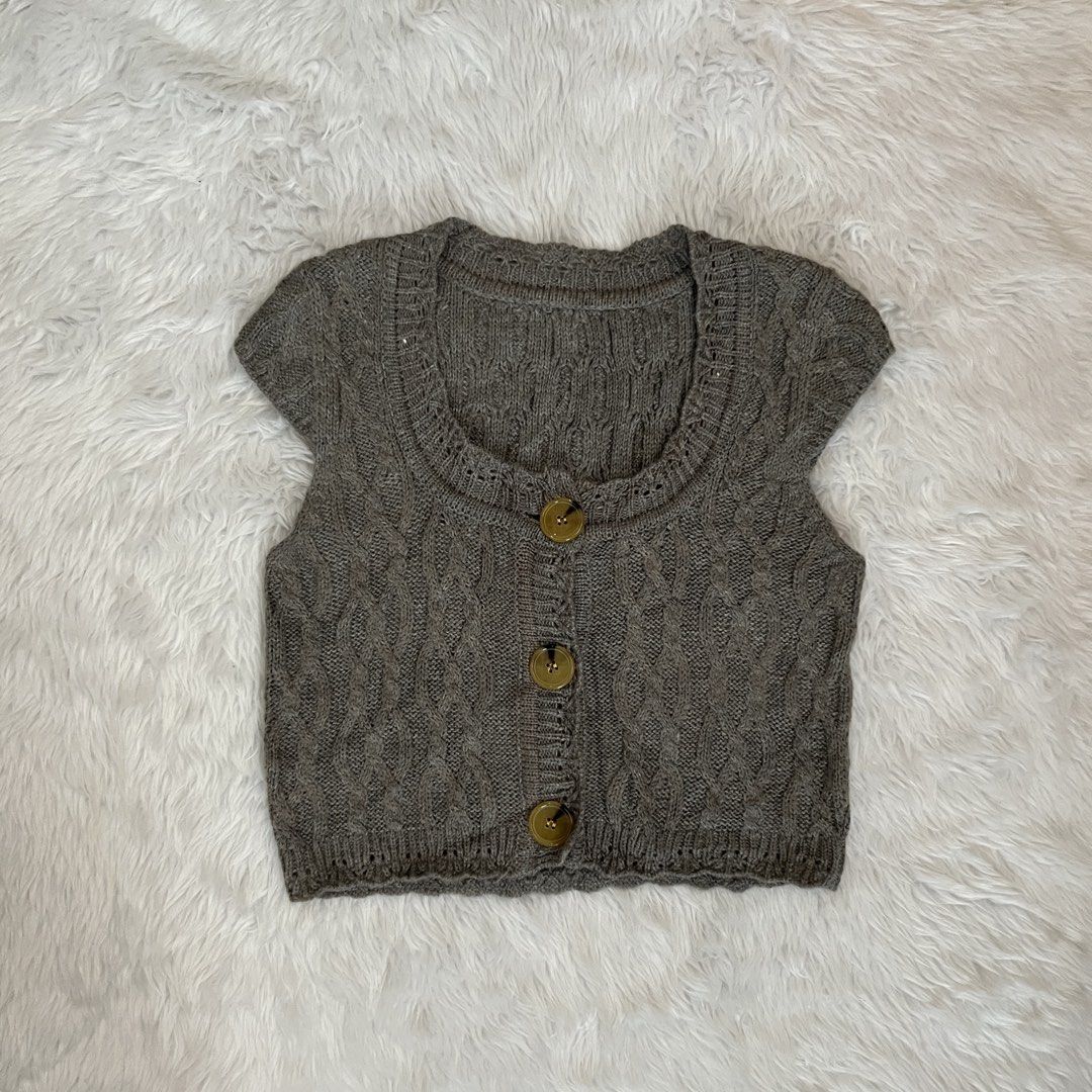 Vintage Cable Knit Button-Up Cap Sleeve Vest Brown (Category: Sleeveless) located in Maasin. Submitted by taraa18 (Listing ID 1469546652, Image 1). Description: - Color: Brown - Design: Cable knit pattern with cap sleeves and a scoop neck - Details: Tortoiseshell buttons down the front - Fit: Cropped - Origin: Made in Hong Kong - Material: Soft knit texture, perfect for layering in cooler weather.