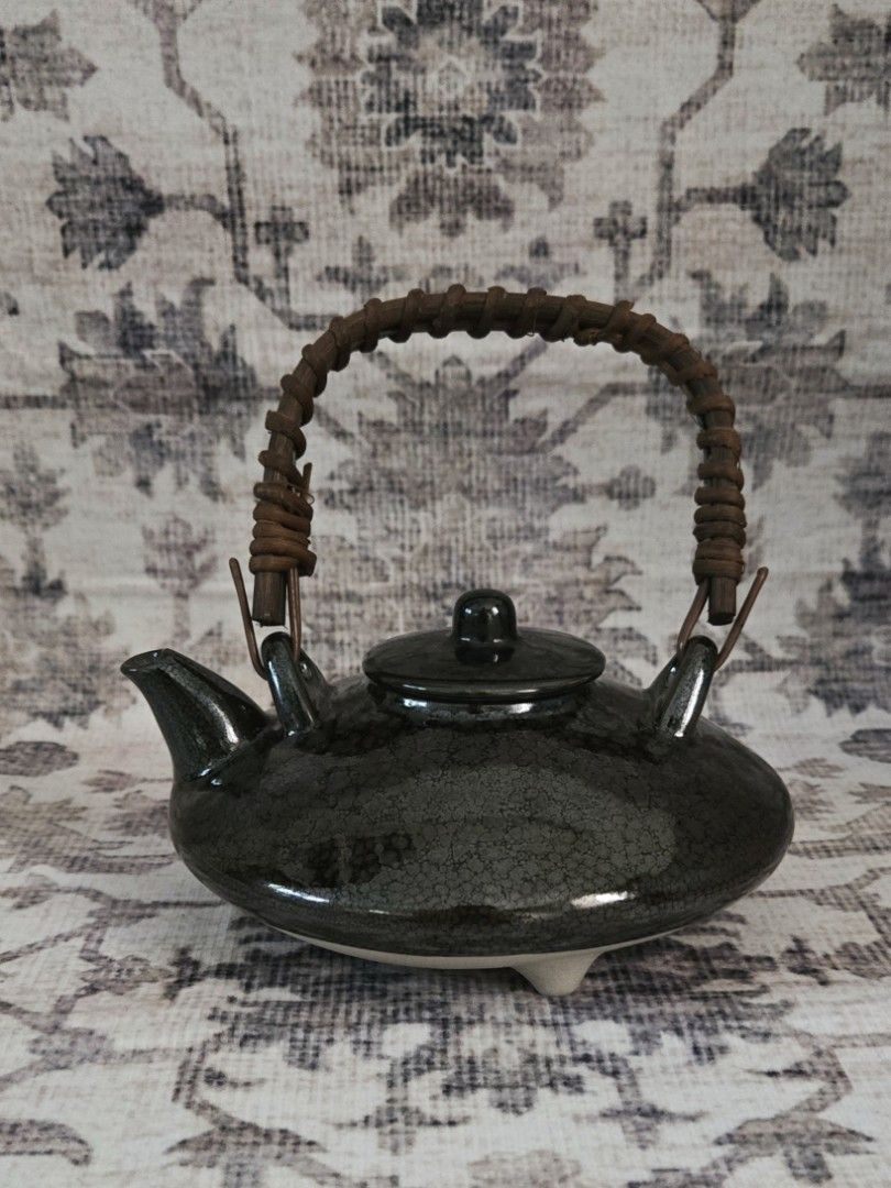 Vintage ceramic teapot (Category: Coffee & Tea Tableware) located in Manila. Submitted by cwknds (Listing ID 1469467732, Image 1). Description: timeless little piece with a dark crackle glaze, rustic woven handle, and a distinctive ufo-like shape. its rounded silhouette gives it a playful yet understated charm, perfect for collectors who appreciate pieces a little out of the ordinary. • 7 x 15 cm • potter's mark ~ personally sourced&curated.