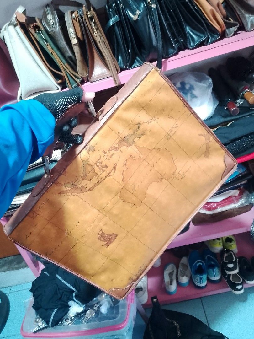 Vintage World Map Print Leather Briefcase Bag (Category: Briefcases) located in Manila. Submitted by romeoamoro00044 (Listing ID 1469493141, Image 3). Description: - Material: Tan leather with antique world map print - Features: Structured interior compartments and sturdy top handle - Closure: Metal push-lock on front flap - Condition: Minor natural wear along edges and corners from regular use - Perfect for work, school, or travel.