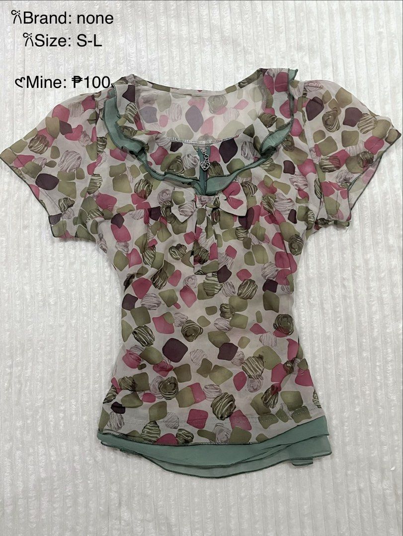 Vintage-style patterned blouse with ruffle collar (Category: Blouses) located in Manila. Submitted by jael_thrift (Listing ID 1469448579, Image 1). Description: - Style: Short sleeve blouse with abstract geometric pattern (pink, green, brown) - Details: Ruffle collar with sage green trim, front zipper opening, and cute ribbon bow - Hem: Double-layered green bottom hem - Material: Lightweight and very comfortable fabric - Fit: Fits sizes S to L.