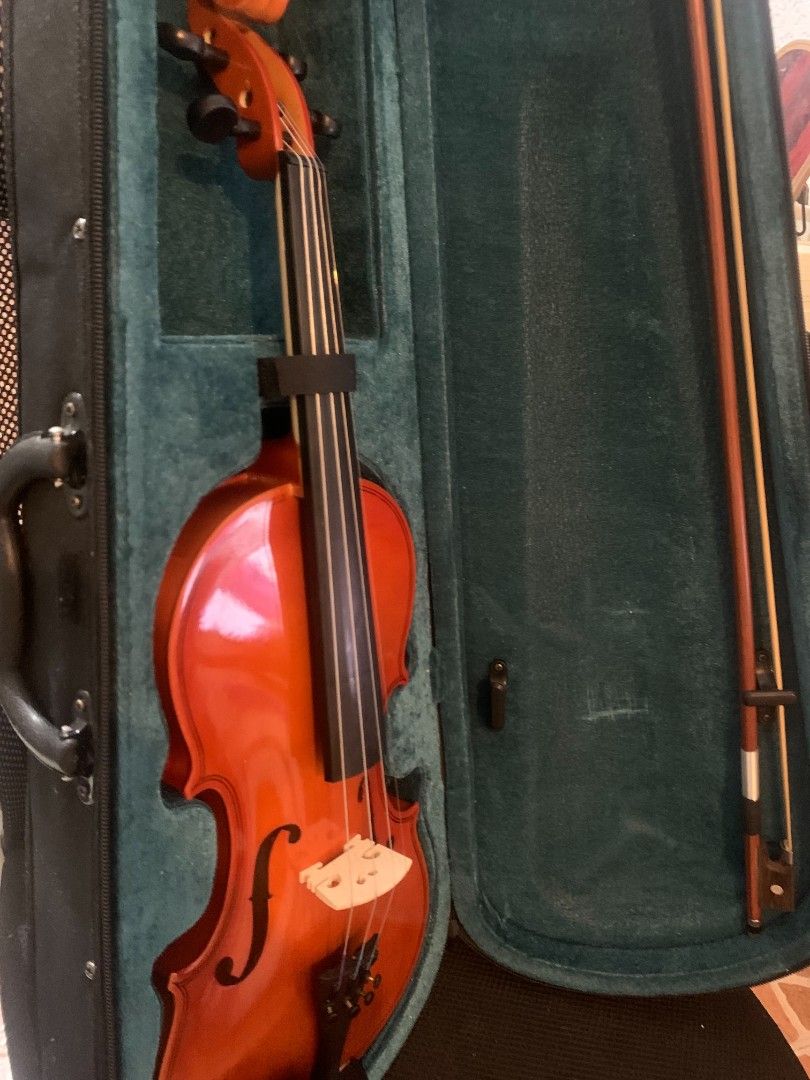 Violin with Hard Case and Bow (For beginner) (Category: Musical Instruments) located in Manila. Submitted by aleahgam6336990 (Listing ID 1469552647, Image 3). Description: - Instrument: Acoustic violin with a glossy orange-brown finish - Included Accessories: Protective hard case with green plush interior and a wooden bow - Setup: Standard four strings, bridge, and tailpiece installed - Condition: Ready for practice or performance .