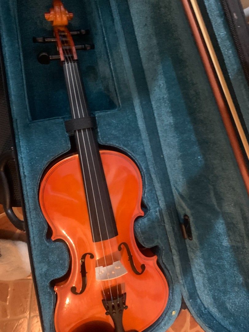 Violin with Hard Case and Bow (For beginner) (Category: Musical Instruments) located in Manila. Submitted by aleahgam6336990 (Listing ID 1469552647, Image 2). Description: - Instrument: Acoustic violin with a glossy orange-brown finish - Included Accessories: Protective hard case with green plush interior and a wooden bow - Setup: Standard four strings, bridge, and tailpiece installed - Condition: Ready for practice or performance .