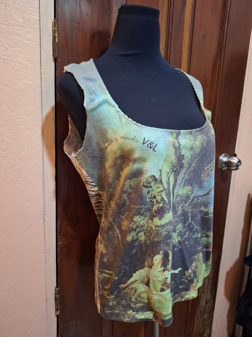 V&L Renaissance Art Print Tank Top (Category: Sleeveless) located in Balamban. Submitted by ubethan (Listing ID 1469487502, Image 2). Description: - Art print tank top featuring a classic landscape painting and V&L branding - Colorway: Green, blue, and brown tones - Design: Sleeveless with a wide scoop neckline and edgy raw, unfinished edges - Details: Unique patterned back panel with animal print - Style: One-of-a-kind, art-inspired wearable pie