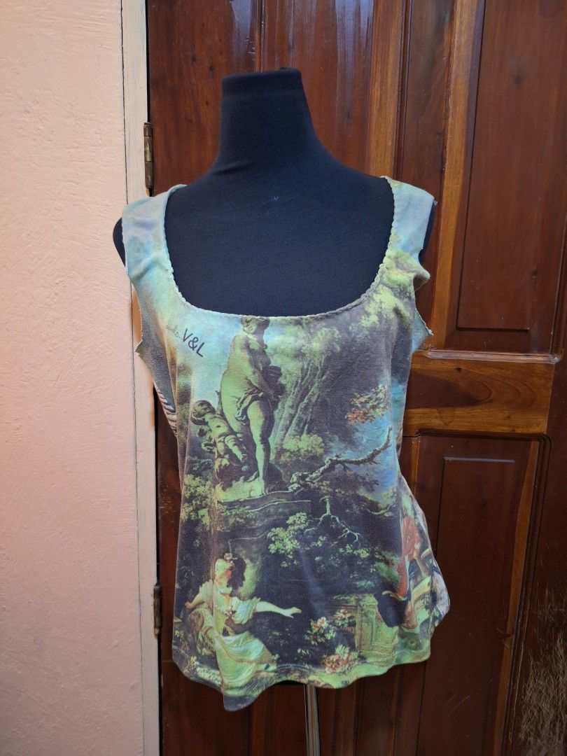 V&L Renaissance Art Print Tank Top (Category: Sleeveless) located in Balamban. Submitted by ubethan (Listing ID 1469487502, Image 1). Description: - Art print tank top featuring a classic landscape painting and V&L branding - Colorway: Green, blue, and brown tones - Design: Sleeveless with a wide scoop neckline and edgy raw, unfinished edges - Details: Unique patterned back panel with animal print - Style: One-of-a-kind, art-inspired wearable pie