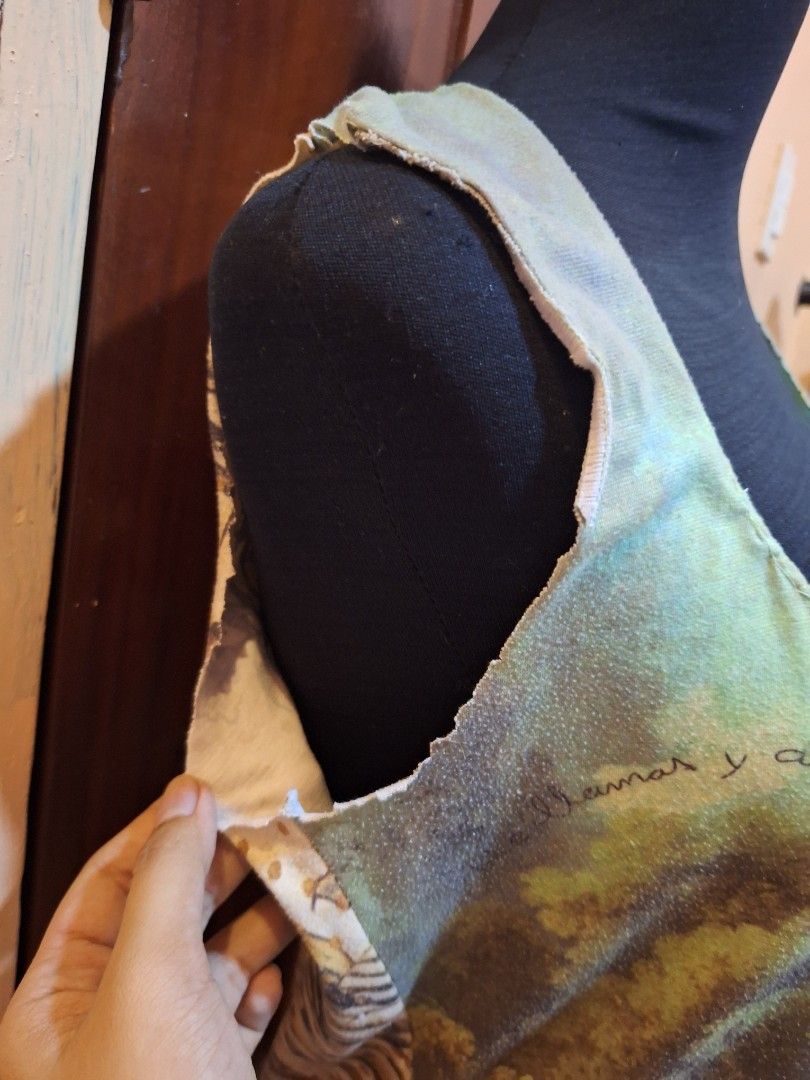 V&L Renaissance Art Print Tank Top (Category: Sleeveless) located in Balamban. Submitted by ubethan (Listing ID 1469487502, Image 3). Description: - Art print tank top featuring a classic landscape painting and V&L branding - Colorway: Green, blue, and brown tones - Design: Sleeveless with a wide scoop neckline and edgy raw, unfinished edges - Details: Unique patterned back panel with animal print - Style: One-of-a-kind, art-inspired wearable pie