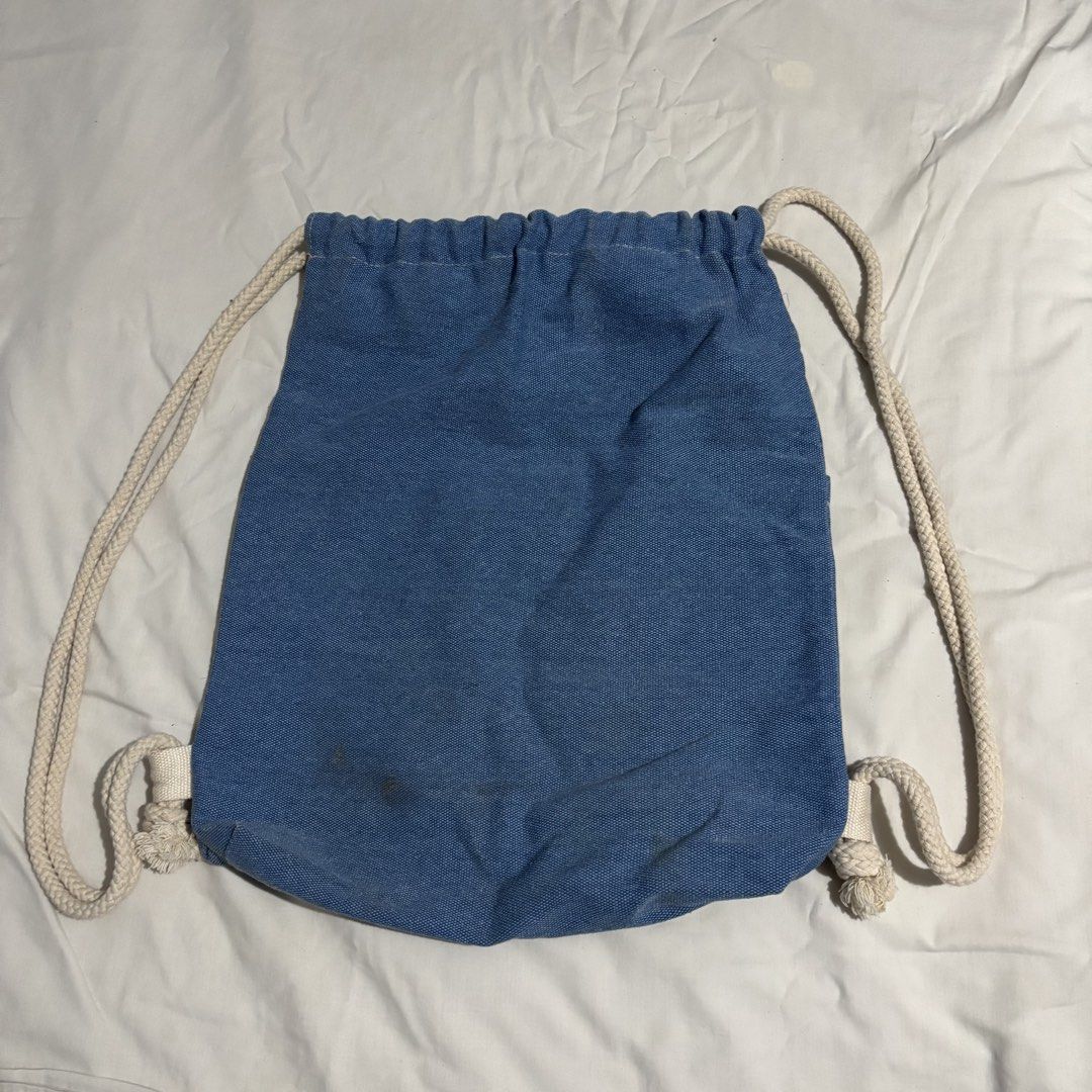 walang problema denim blue drawstring bag (Category: Backpacks) located in Las Pinas. Submitted by tteok0325 (Listing ID 1469533009, Image 3). Description: - blue denim-style canvas drawstring backpack - with thick white rope straps - bought in el nido - has stains but can be washed naman mop: gcash or maribank mod: jnt or lalamove.