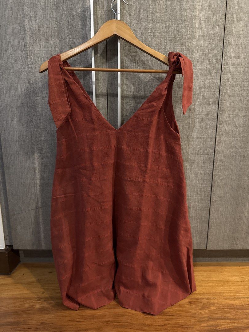 Wear Anika Dress (Category: Rompers) located in Makati City. Submitted by kkk.shops (Listing ID 1469510243, Image 1). Description: - Color: Rust orange with all-over textured horizontal stripes - Neckline: Trendy deep V-neck front - Straps: Adjustable tie-up shoulders for a custom fit - Fit: Relaxed and easy to slip on - Fabric: Lightweight and perfect for casual wear.
