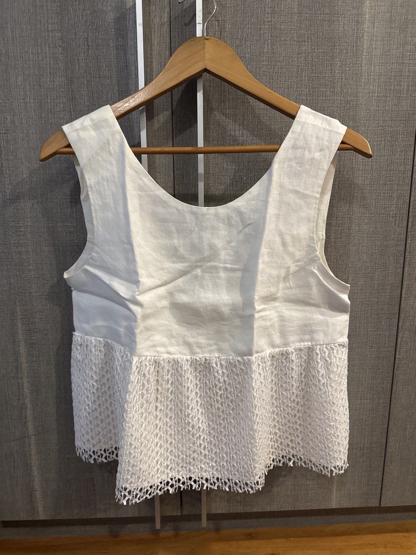 Wear Anika Top (Category: Sleeveless) located in Makati City. Submitted by kkk.shops (Listing ID 1469514347, Image 1). Description: - Color: White - Style: Sleeveless top with scoop neckline - Design: Solid fabric upper half with a chic mesh patterned overlay on the lower half - Fit: Relaxed and comfortable - Versatility: Perfect for warm weather, easy to match with shorts or jeans.