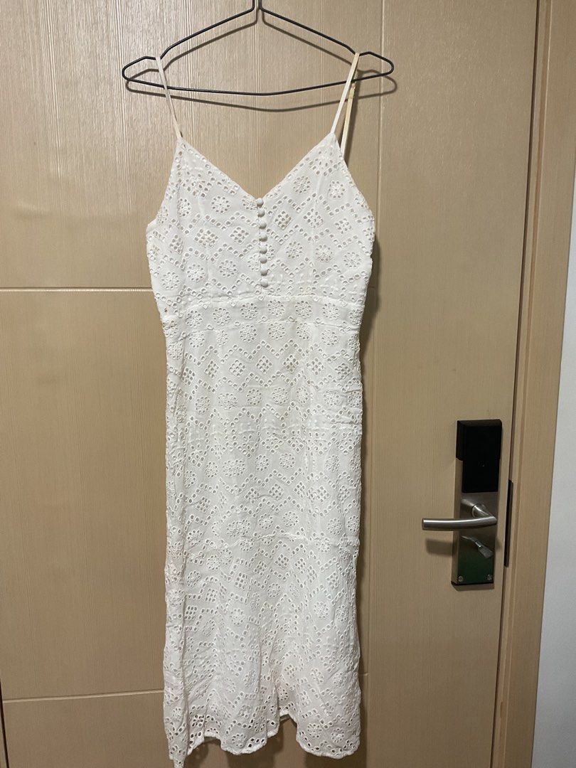 White Eyelet Spaghetti Strap Midi Dress with Buttons (Category: Dresses) located in Quezon City. Submitted by patriciam.02 (Listing ID 1469496408, Image 3). Description: - Style: White eyelet midi dress with textured pattern - Details: Spaghetti straps, decorative button front, back zipper closure - Condition: Noticeable yellowing and stains on shoulder straps and back zipper area - Note: Selling as-is, perfect for a DIY project or thorough clean
