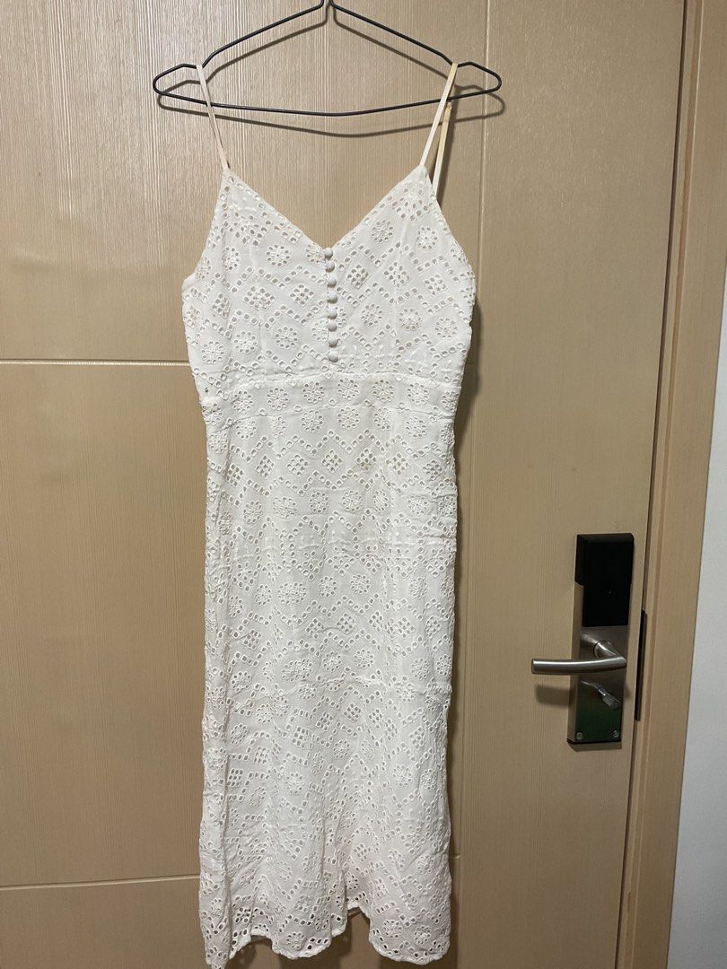 White Eyelet Spaghetti Strap Midi Dress with Buttons (Category: Dresses) located in Quezon City. Submitted by patriciam.02 (Listing ID 1469496408, Image 2). Description: - Style: White eyelet midi dress with textured pattern - Details: Spaghetti straps, decorative button front, back zipper closure - Condition: Noticeable yellowing and stains on shoulder straps and back zipper area - Note: Selling as-is, perfect for a DIY project or thorough clean
